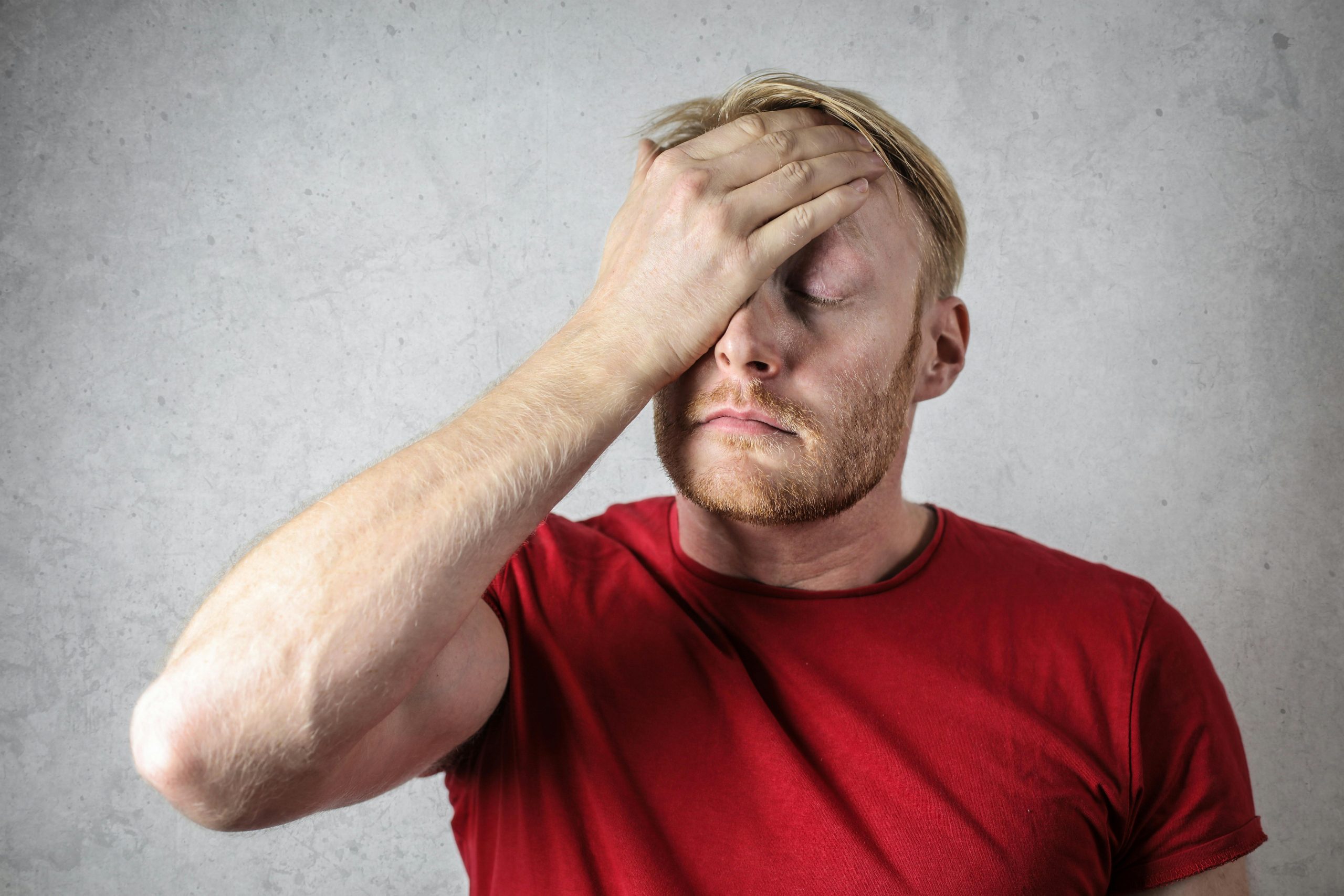 disappointed man with one hand on his forehead