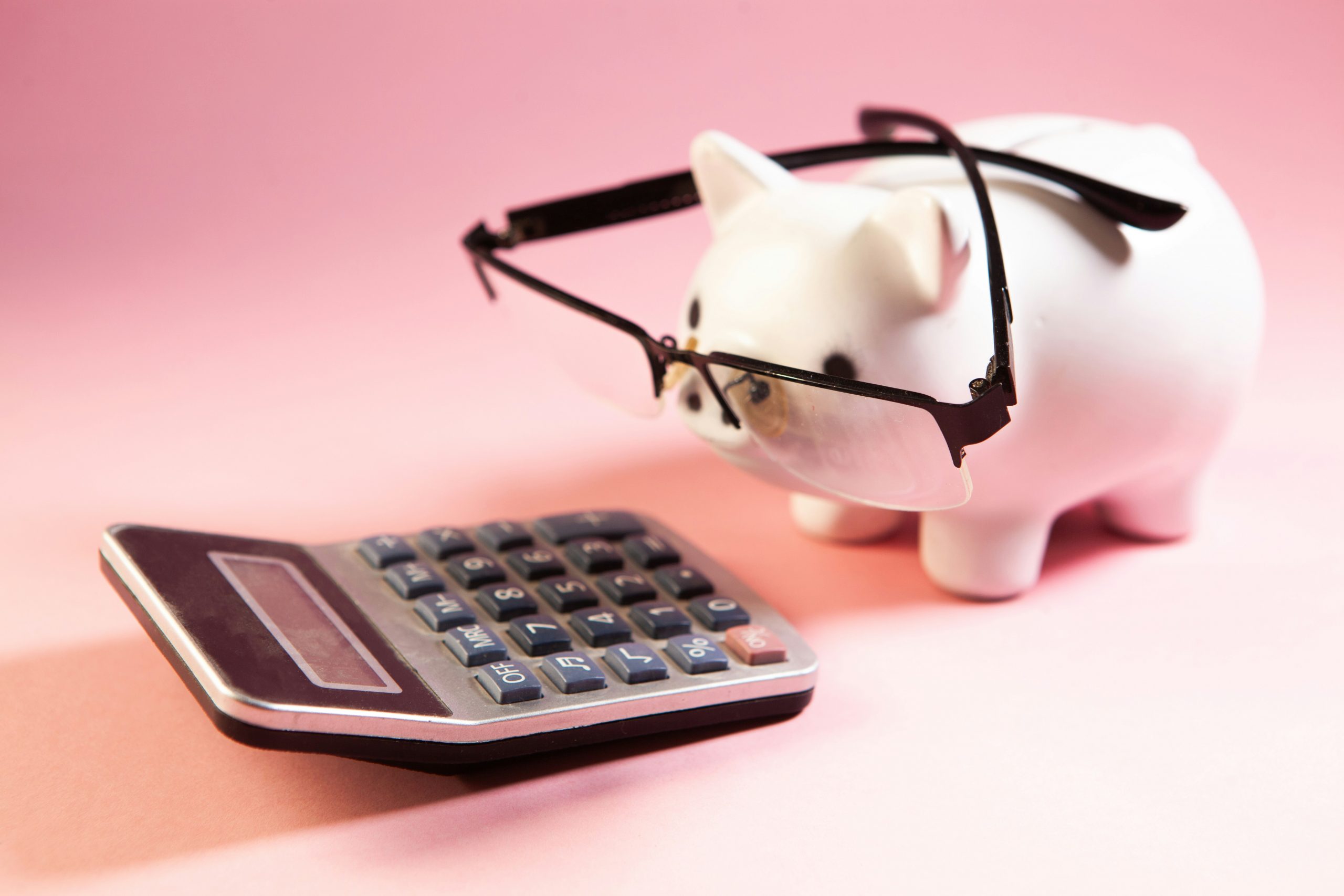 a calculator and a piggy bank wearing eyeglasses